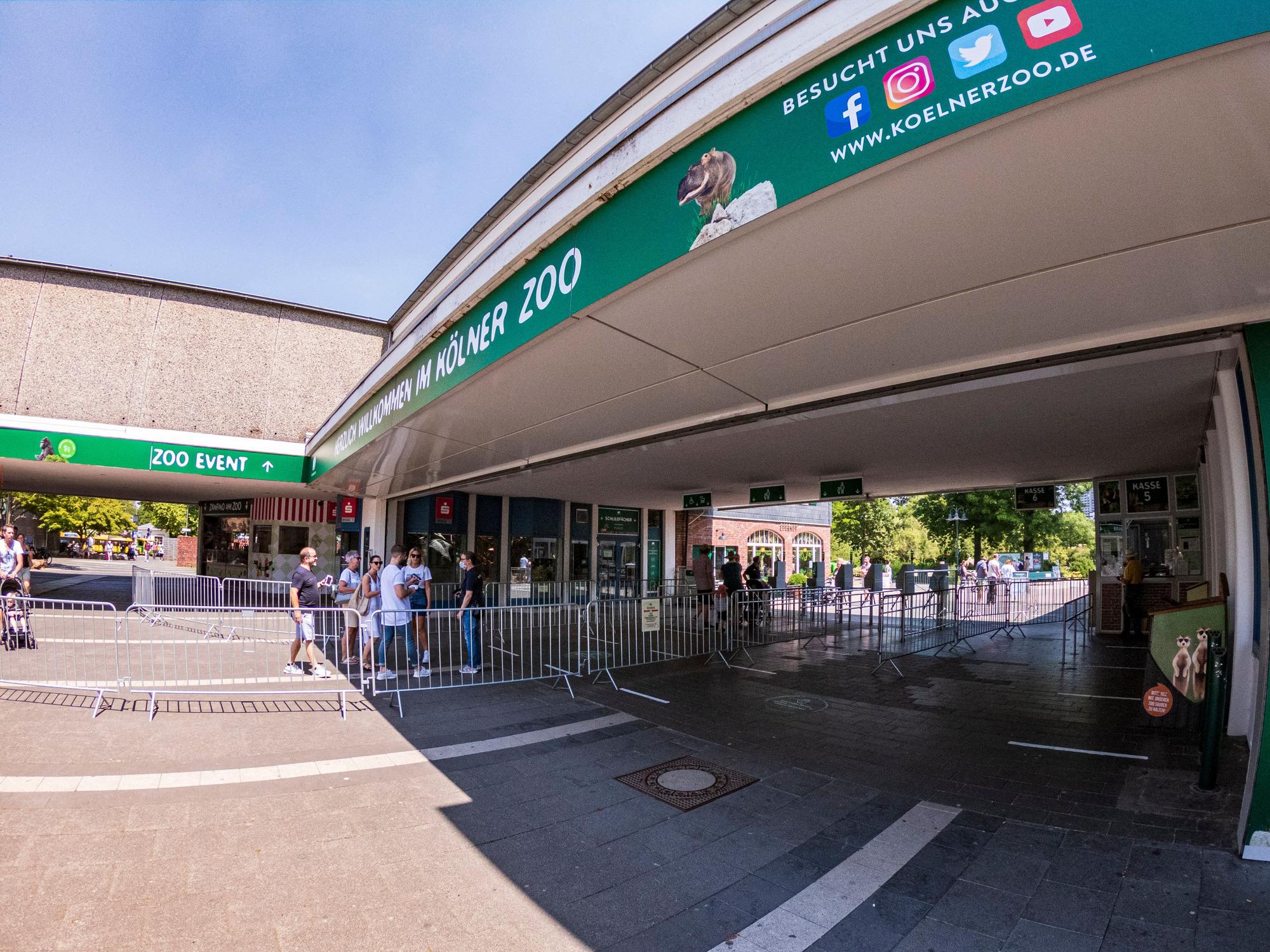 Menschen stehen vor dem Eingang des Kölner Zoos.