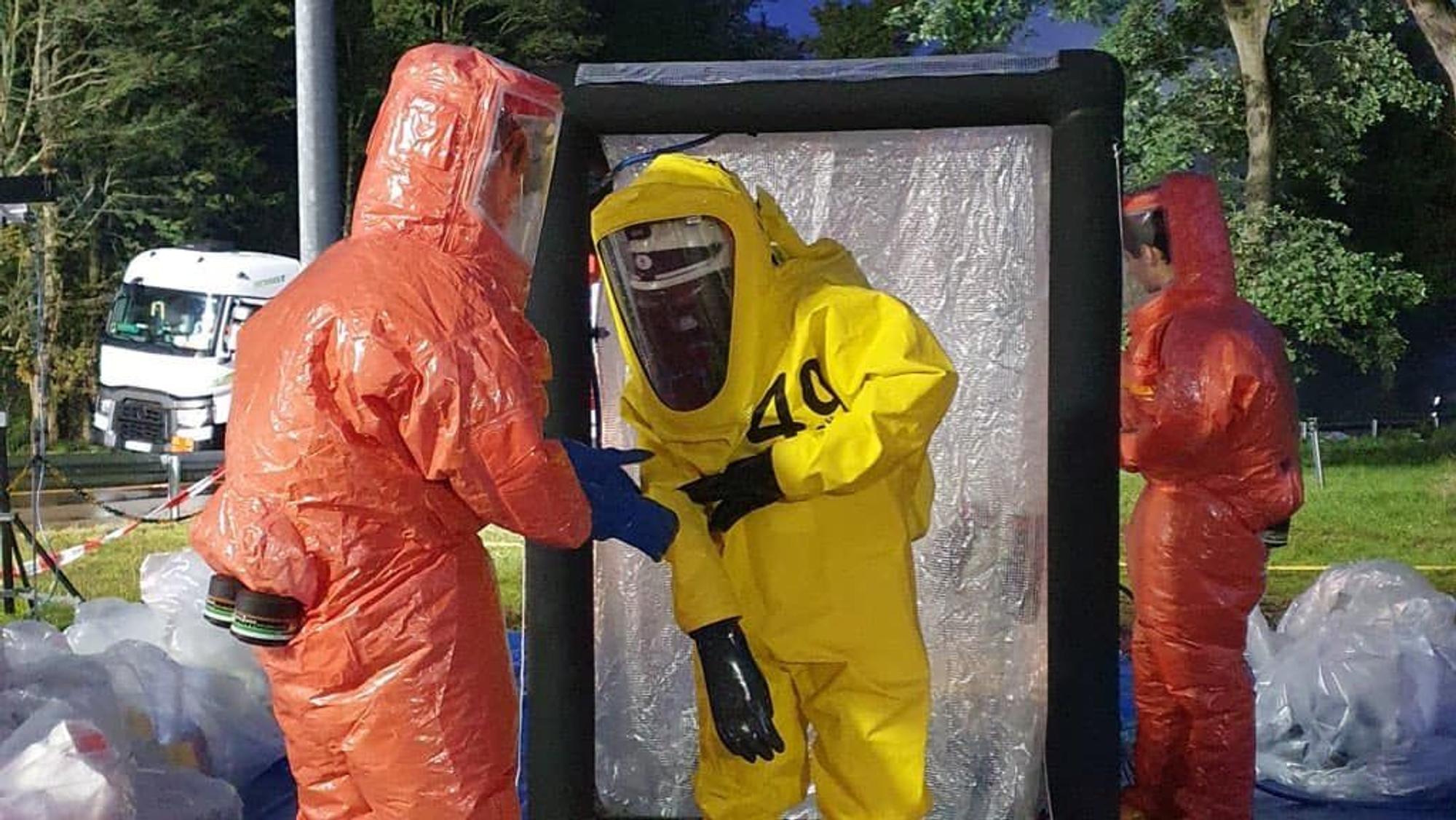 Das Foto vom Einsatzort in Rösrath zeigt die Feuerwehrkräfte, die Spezialanzüge tragen mussten. Sie sollen vor der gefährlichen Salzsäure schützen.
