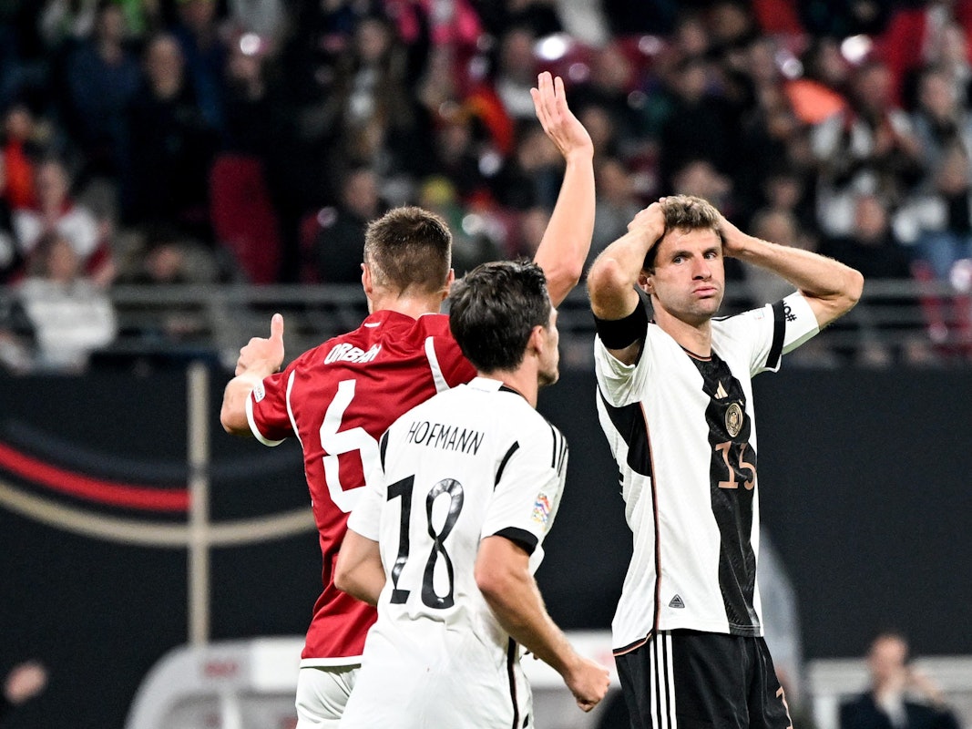Thomas Müller (r) fasst sich an den Kopf. Neben ihm stehen sein Teamgefährte Jonas Hofmann (M) und Willi Orban von Ungarn.