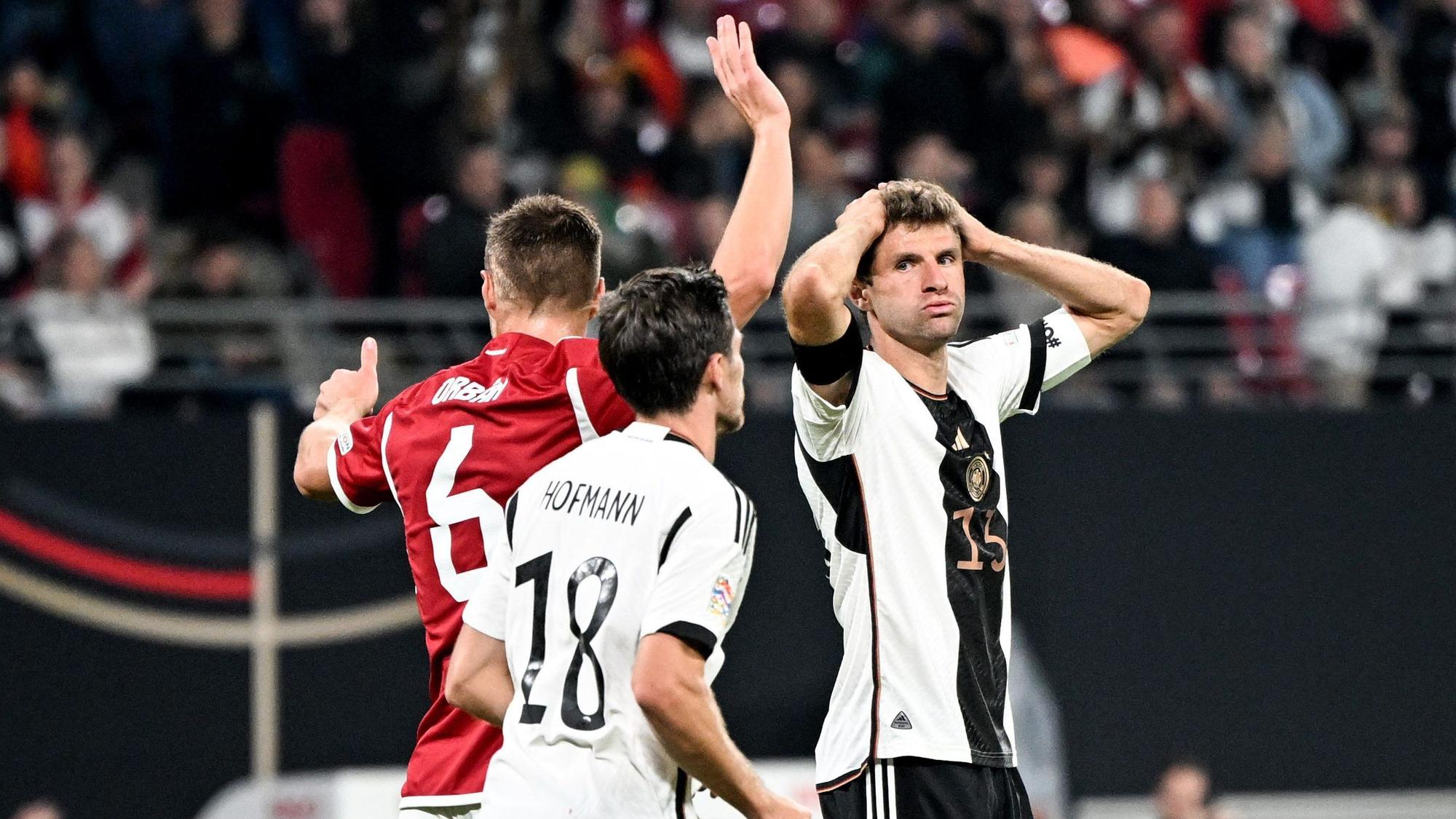 Thomas Müller (r) fasst sich an den Kopf. Neben ihm stehen sein Teamgefährte Jonas Hofmann (M) und Willi Orban von Ungarn.