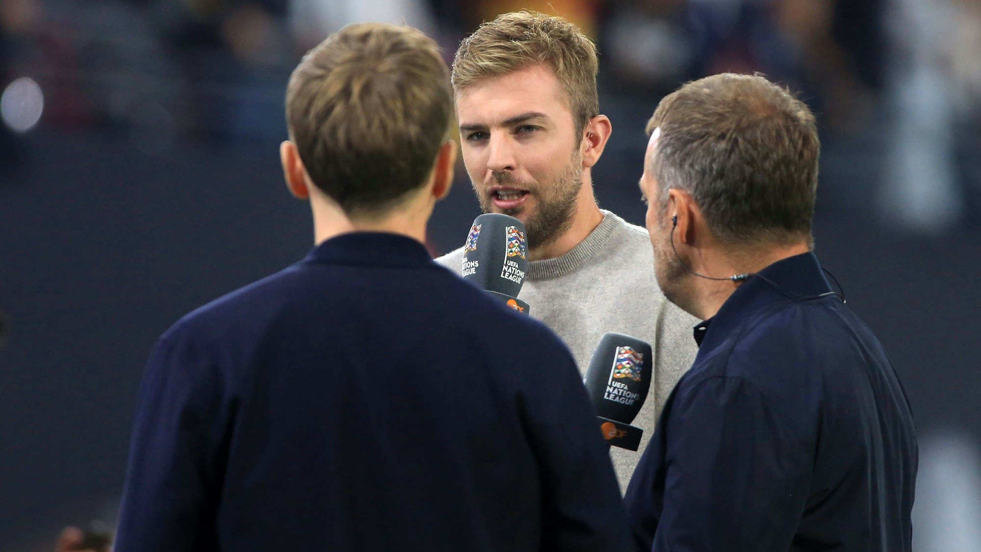 Christoph Kramer spricht als TV-Experte neben Trainer Hansi Flick.