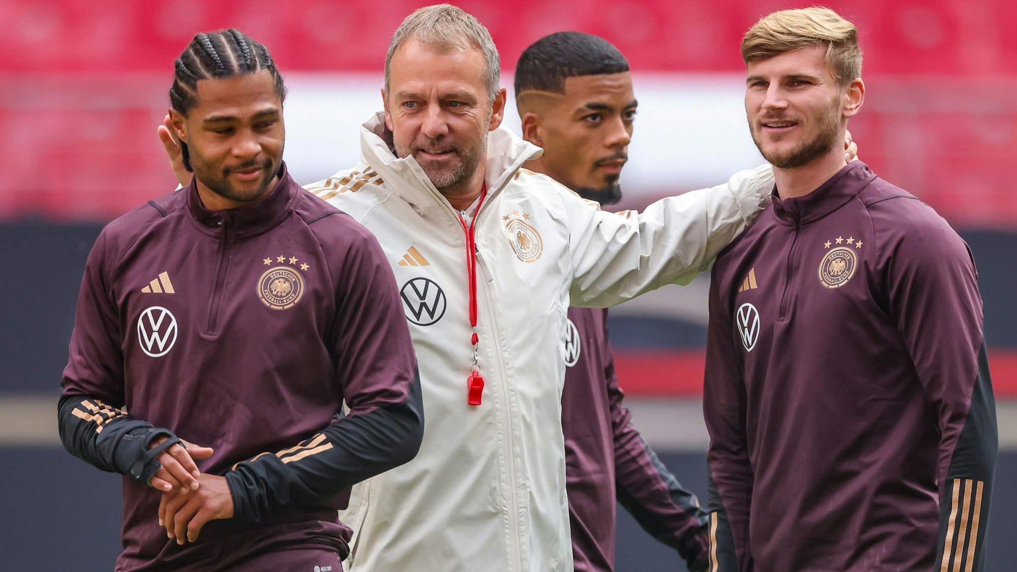 Bundestrainer Hansi Flick (M) und die Spieler Serge Gnabry (l-r), Benjamin Henrichs und Timo Werner stehen während des Trainings im Stadion.