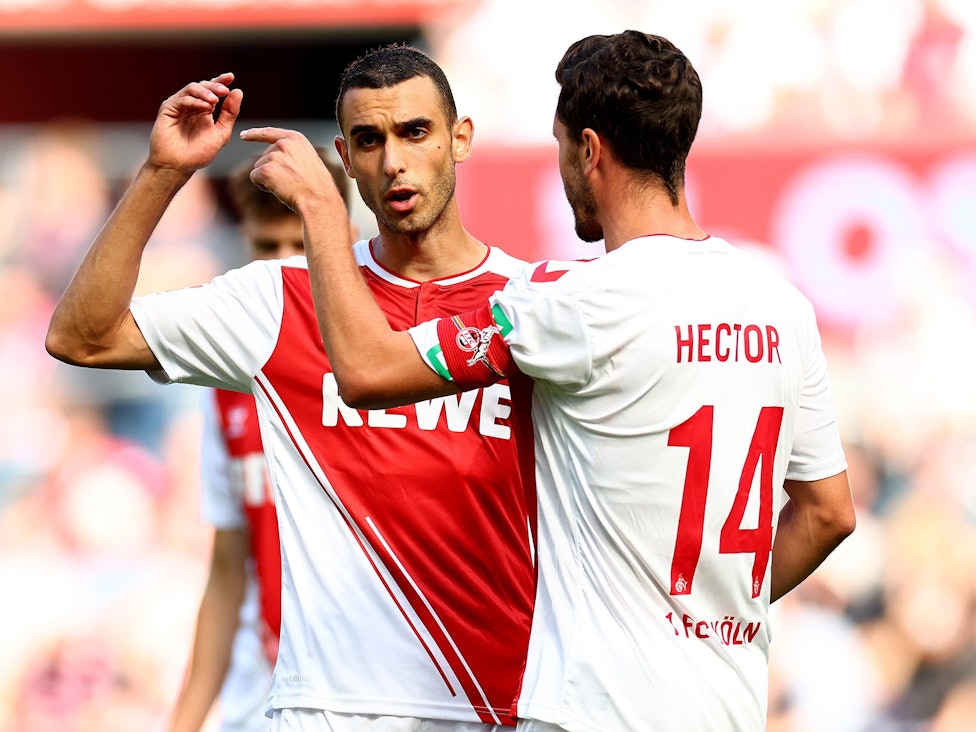 Jonas Hector spricht mit Ellyes Skhiri auf dem Platz.