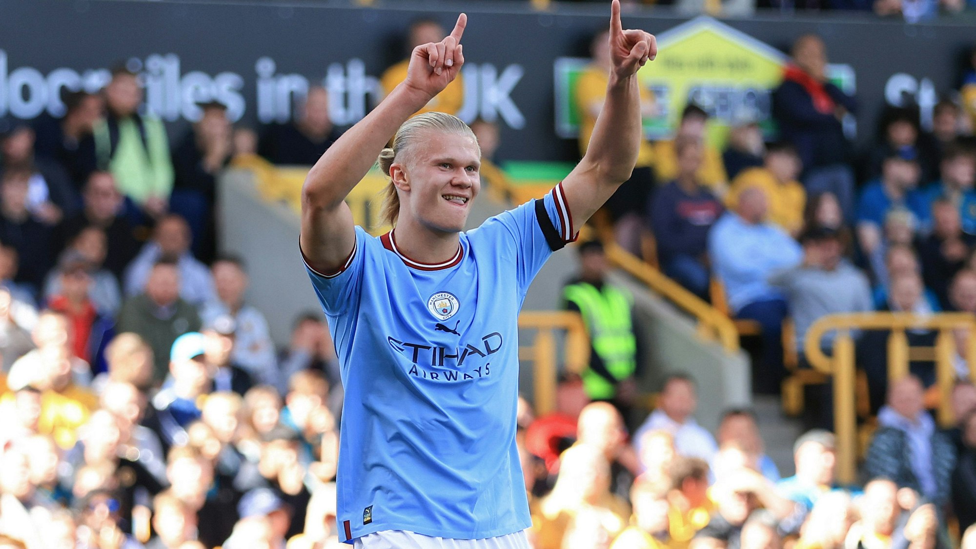 Erling Haaland jubelt lachend über ein Tor und hält die Arme dabei über den Kopf (17. September 2022).