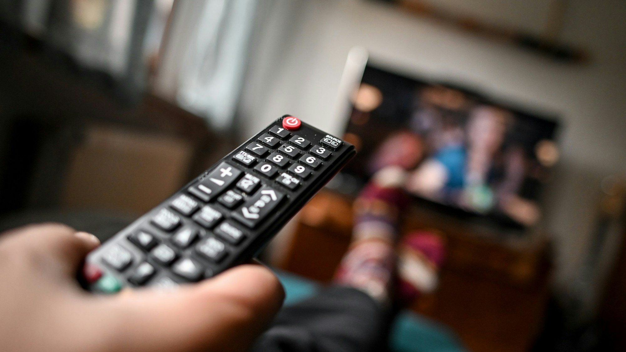 ProSieben ändert ab Sonntag (25. September) sein Abendprogramm. Unser Symbolbild zeigt einen jungen Mann mit einer Fernbedienung.