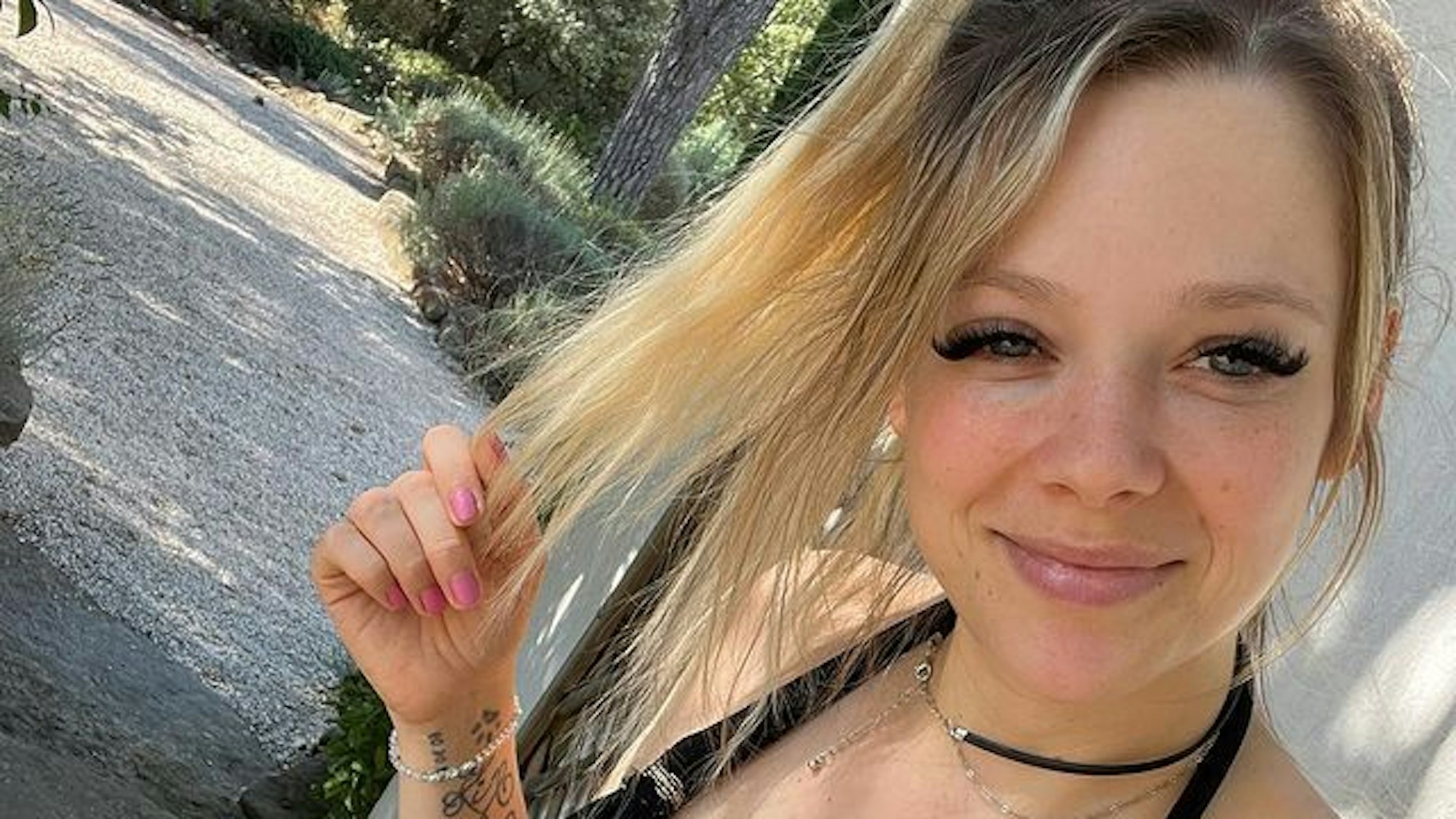 Für ein Selfie posiert Anne in einem schwarzen Kleid. Lächelnd blickt sie in die Kamera.