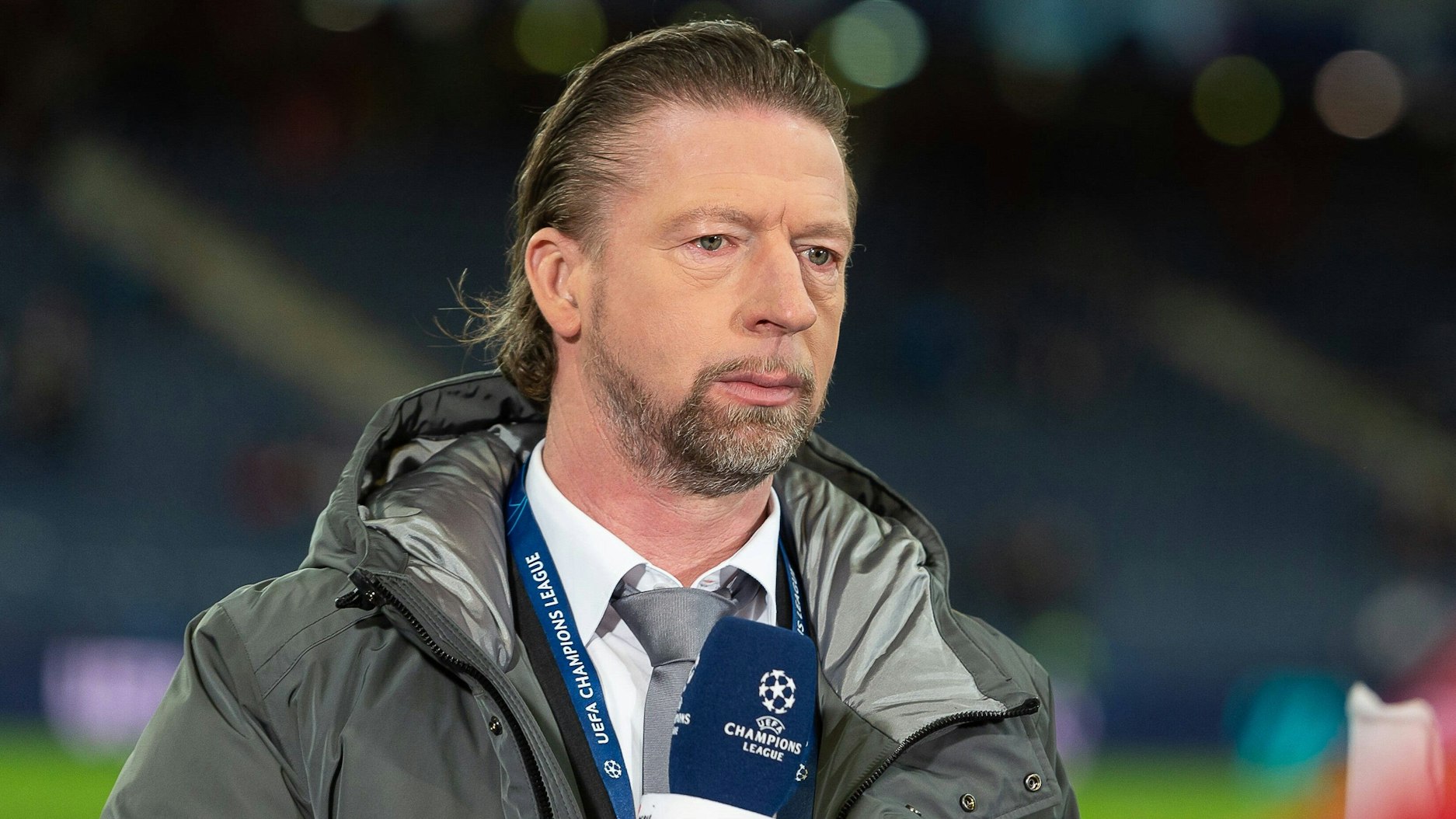 Steffen Freund hält als Experte am TV-Pult ein Mikro in der Hand