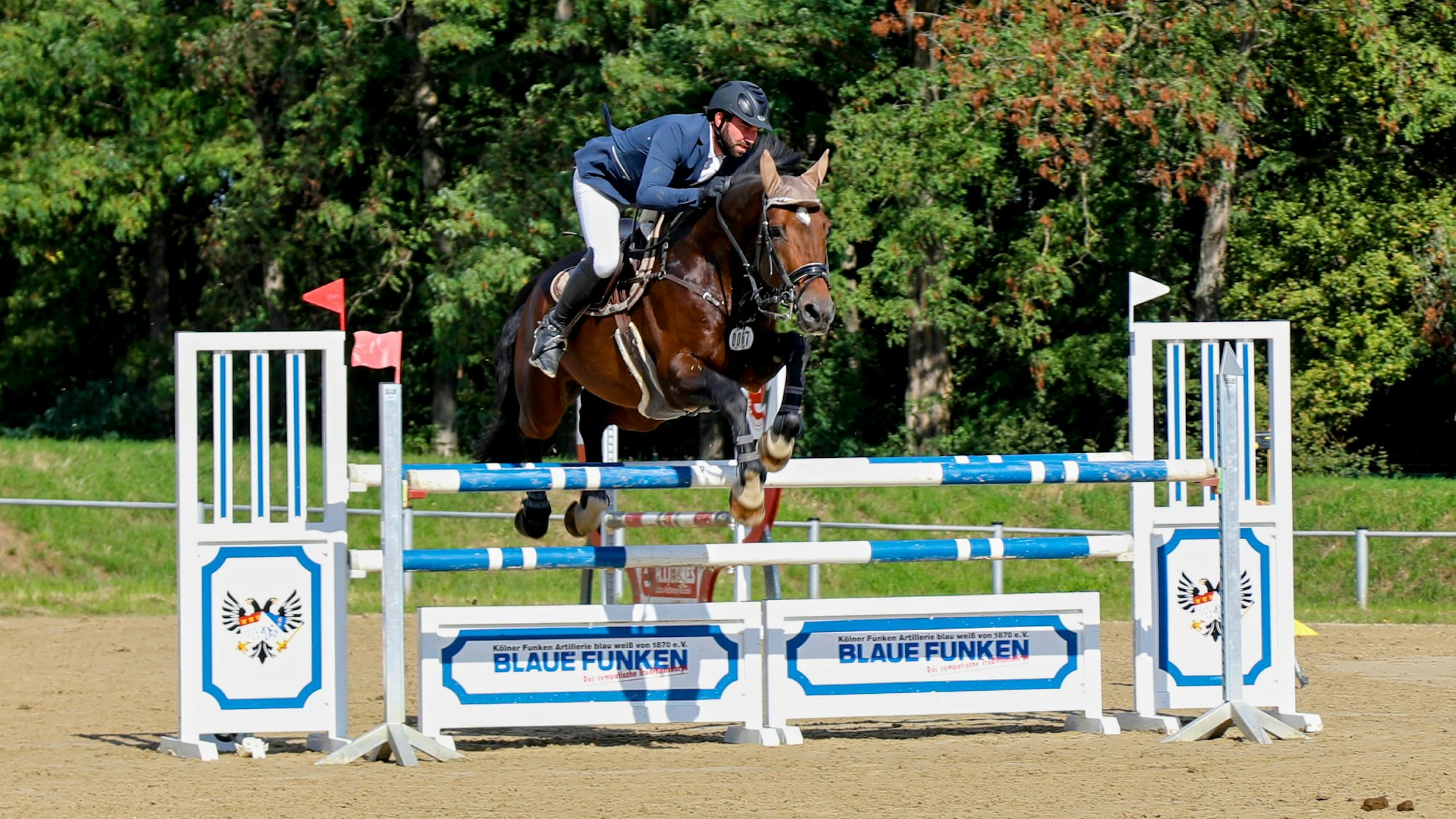 Ein Reiter setzt über ein Hindernis.