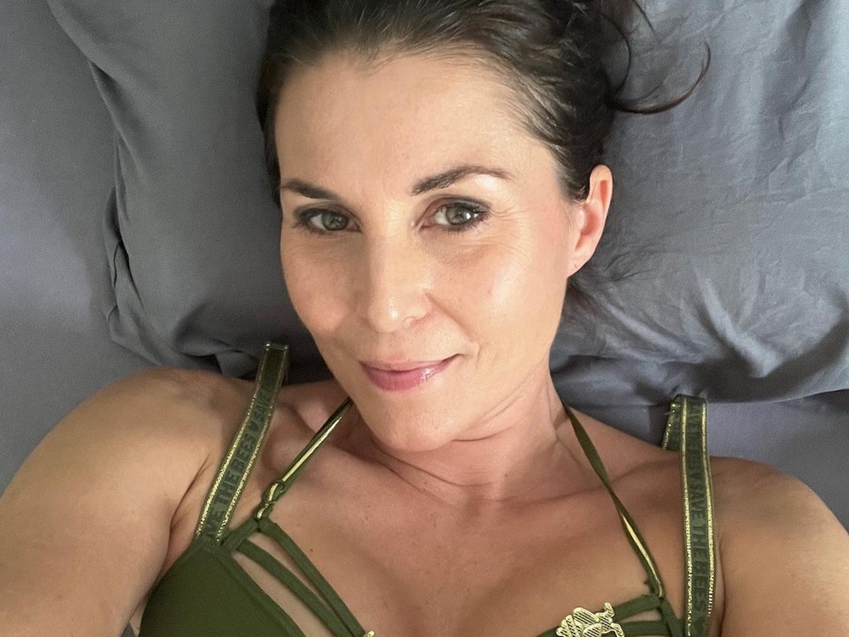 Auf dem Selfie schaut Vanessa in die Kamera. Sie trägt einen dunkelgrünen Bikini mit goldfarbenen Details.