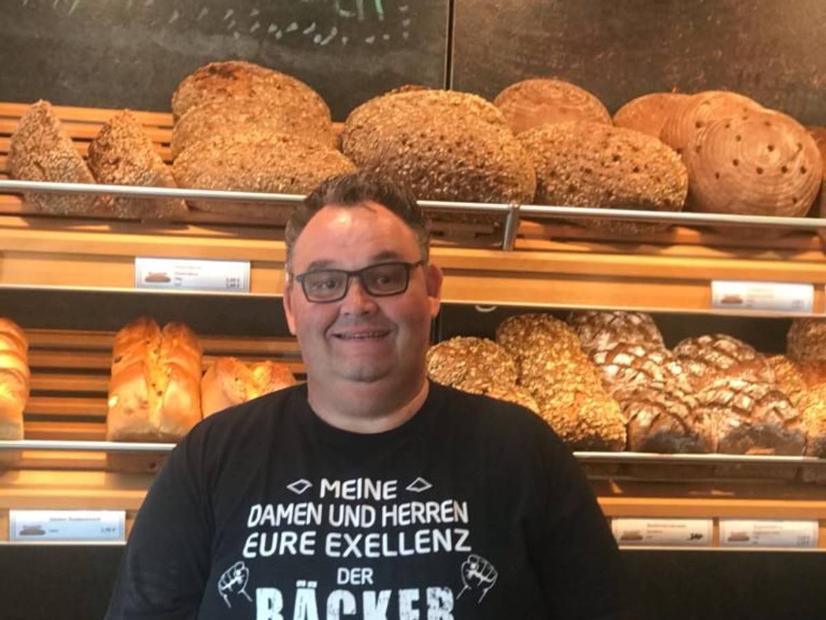 Bäcker Gudio Boveleth steht in seiner Bäckerei vor einem Brotregal.