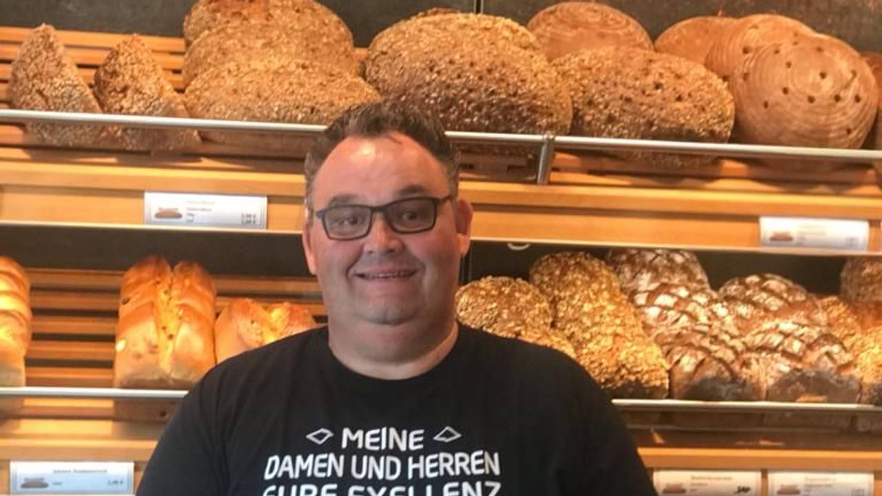 Bäcker Gudio Boveleth steht in seiner Bäckerei vor einem Brotregal.