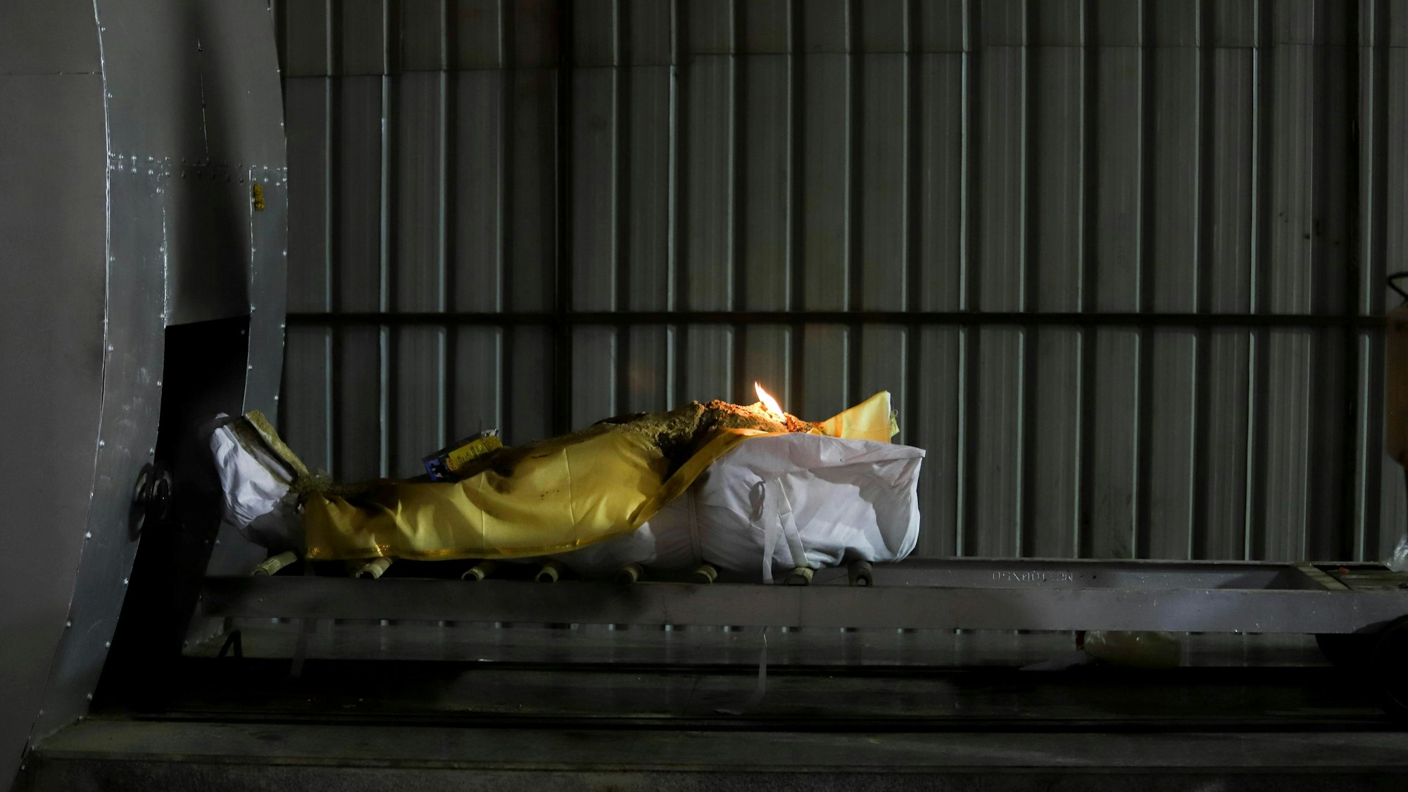 Die Leiche eines Menschen, der im Zusammenhang mit dem Coronavirus gestorben ist, wird am 16. April 2021 in die Verbrennungskammer des Nigambodh Ghat Krematoriums in Delhi gefahren.