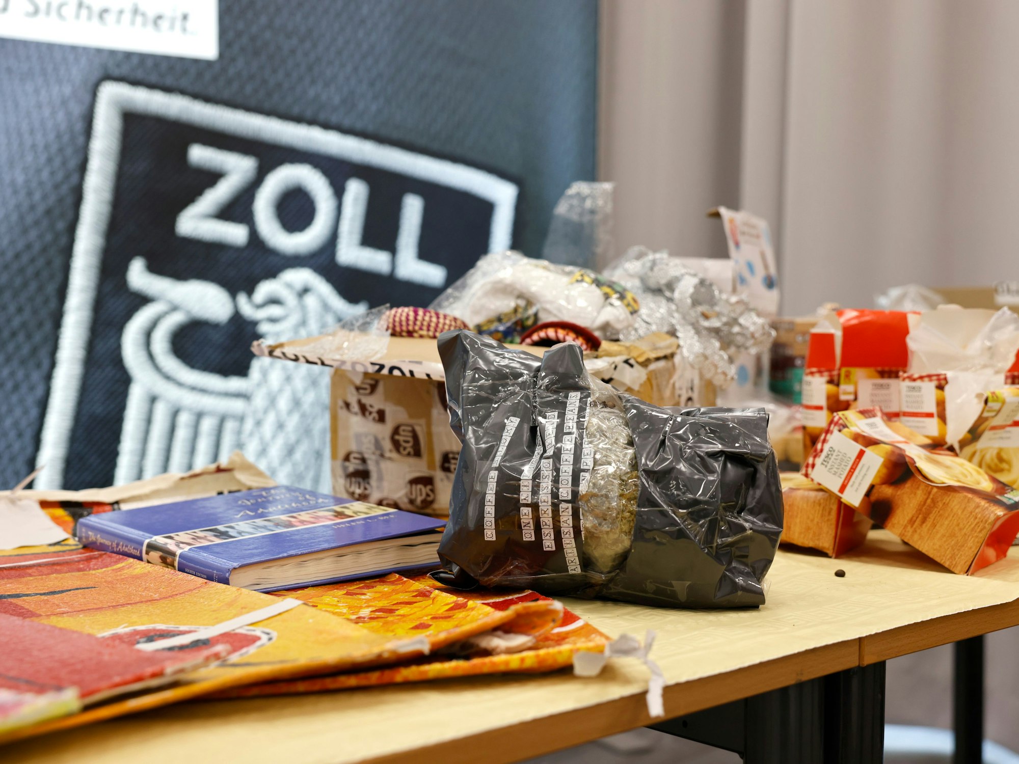Auf einem Tisch im Zollamt Köln liegen diverse sichergestellte Drogen und deren Verpackungen, die als Verstecke genutzt wurden.