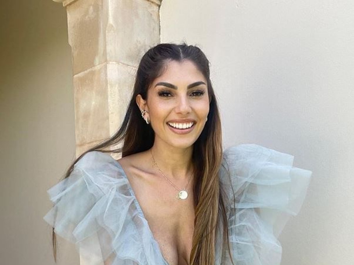 Yeliz Koc lacht in einem durchsichtigen, blauen Kleid in die Kamera.