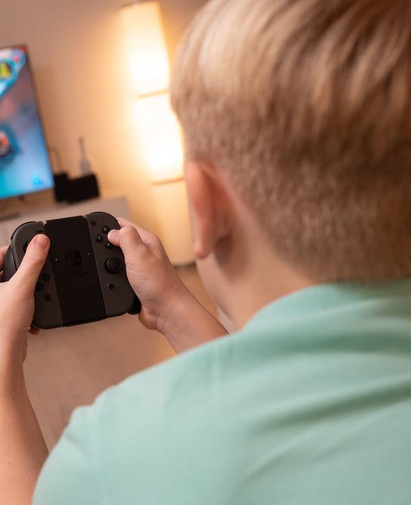 Ein Junge spielt an einer Konsole im Wohnzimmer