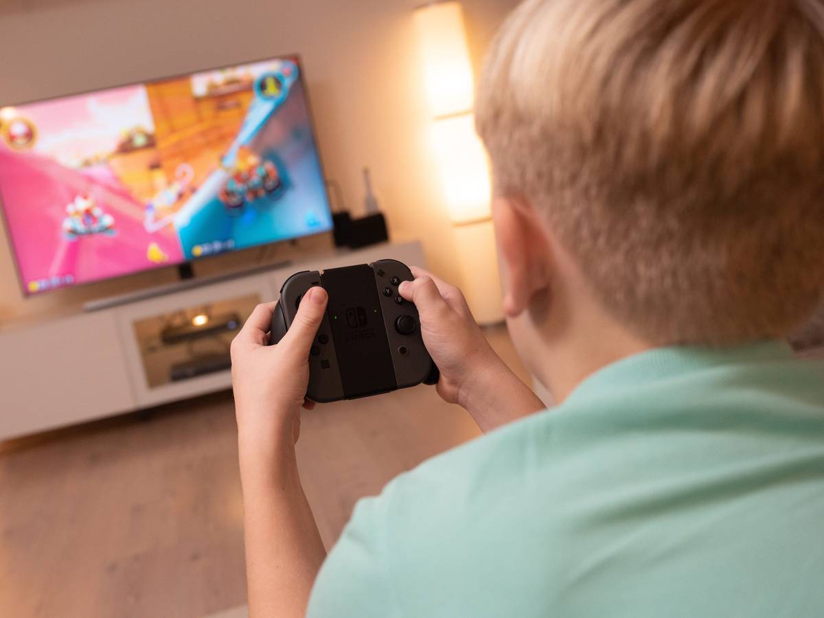 Ein Junge spielt an einer Konsole im Wohnzimmer