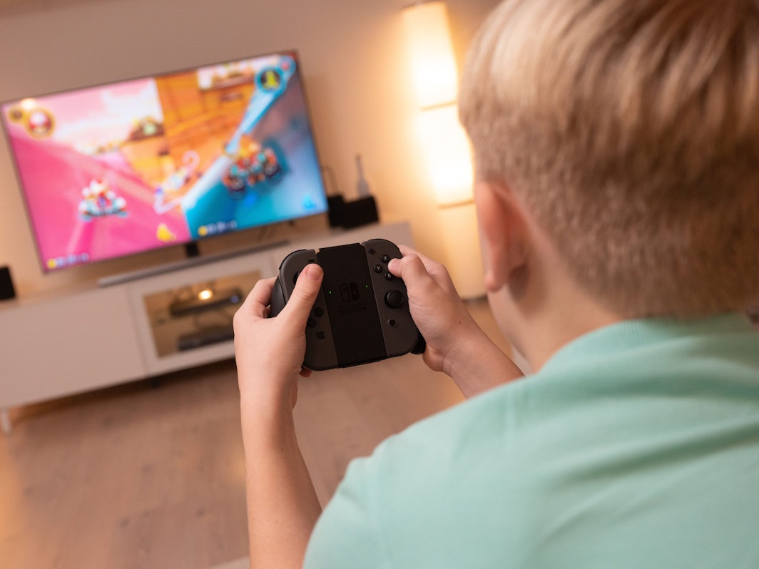 Ein Junge spielt an einer Konsole im Wohnzimmer