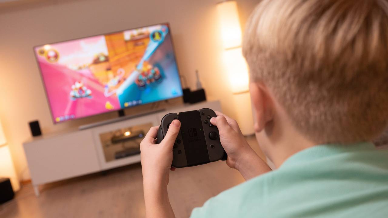 Ein Junge spielt an einer Konsole im Wohnzimmer