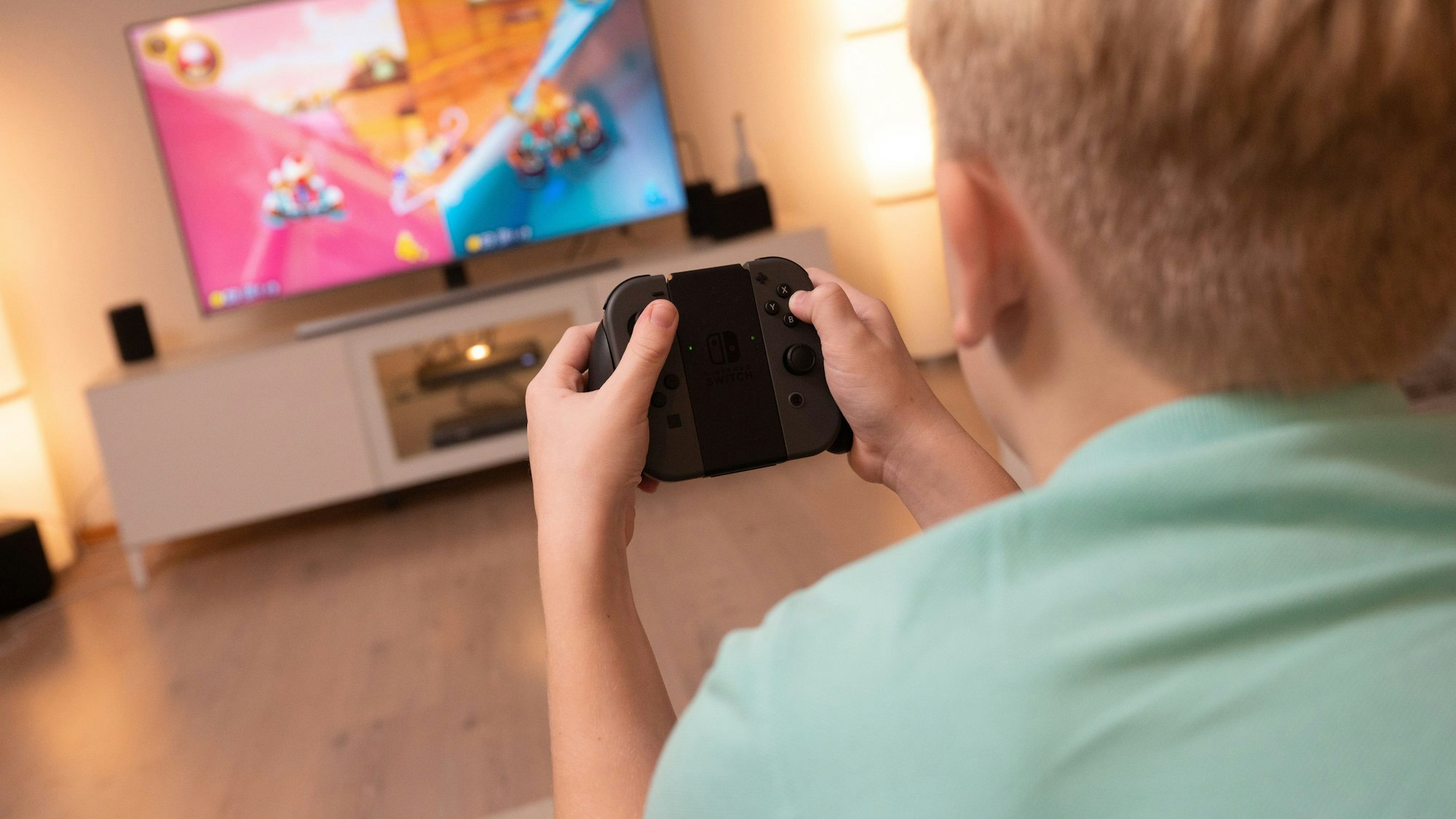 Ein Junge spielt an einer Konsole im Wohnzimmer