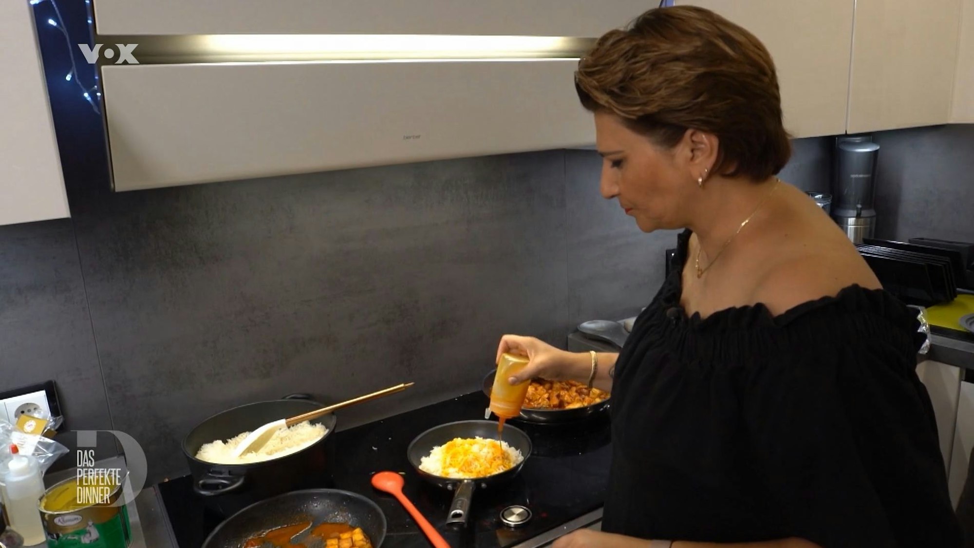Sonja steht am Herd und bereitet den Reis zu.