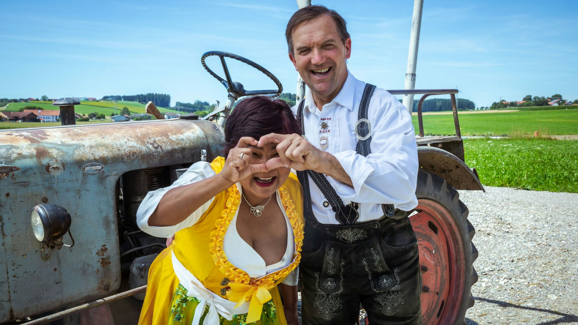 Narumol und Josef formen ein Herz mit ihren Händen