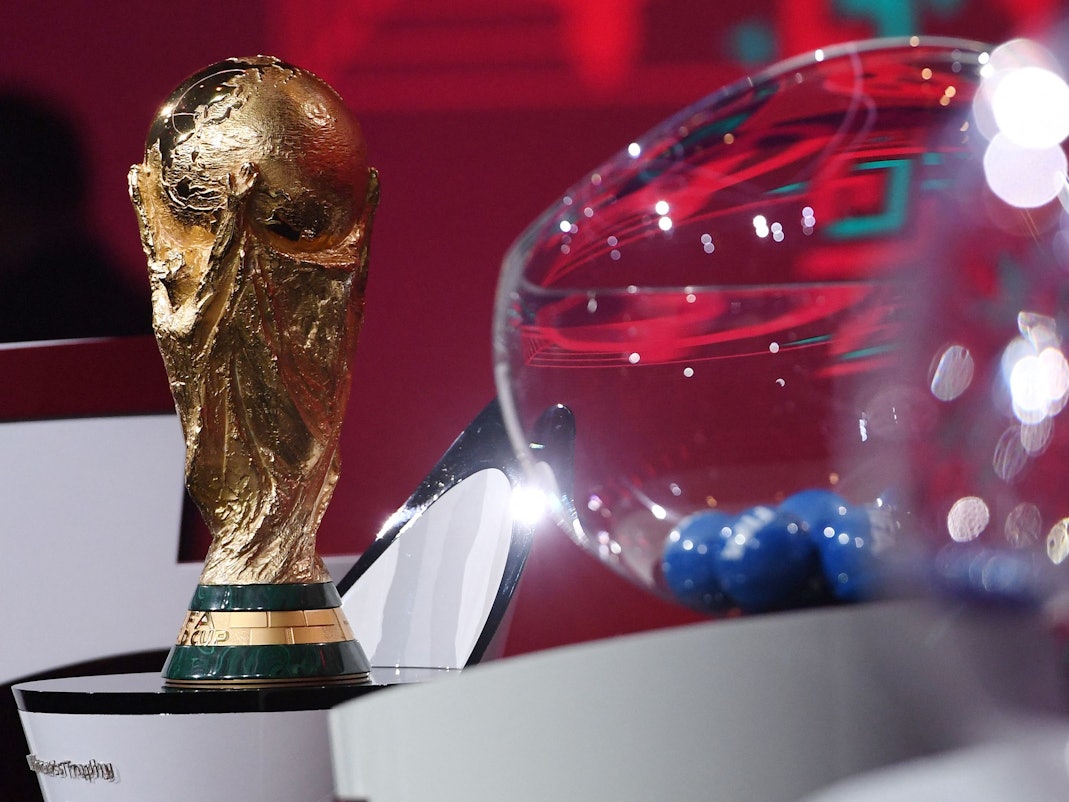 Der WM-Pokal steht bei der Quali-Auslosung neben einer Lostrommel der FIFA