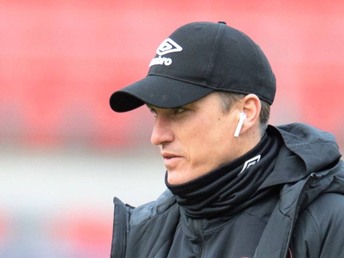 Tobias Schweinsteiger geht vor einem Spiel der 2. Bundesliga mit Kopfhörern in den Ohren über den Rasen