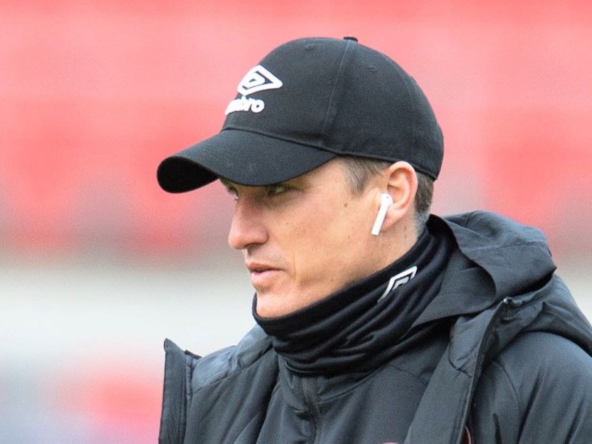 Tobias Schweinsteiger geht vor einem Spiel der 2. Bundesliga mit Kopfhörern in den Ohren über den Rasen
