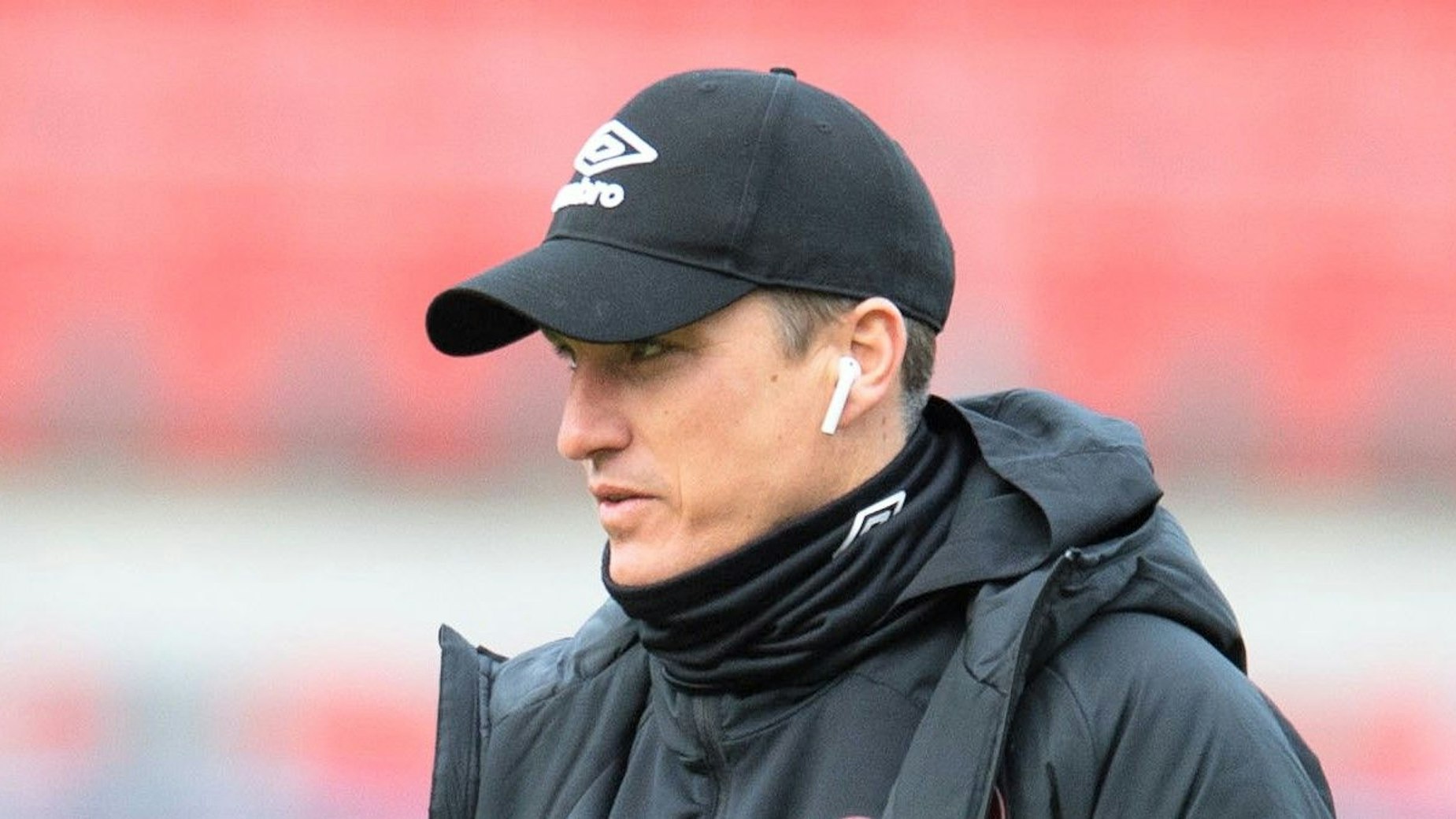 Tobias Schweinsteiger geht vor einem Spiel der 2. Bundesliga mit Kopfhörern in den Ohren über den Rasen