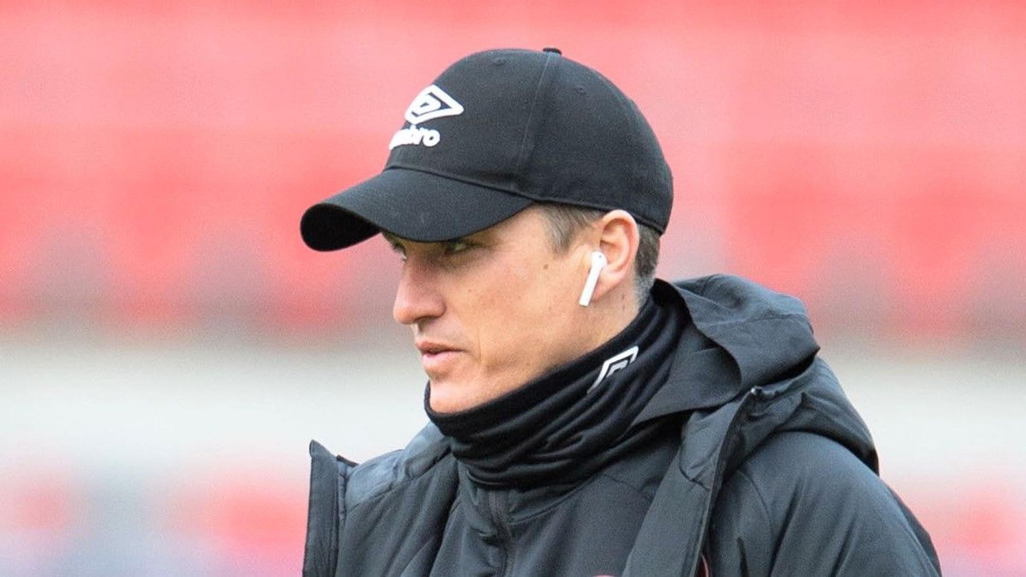 Tobias Schweinsteiger geht vor einem Spiel der 2. Bundesliga mit Kopfhörern in den Ohren über den Rasen