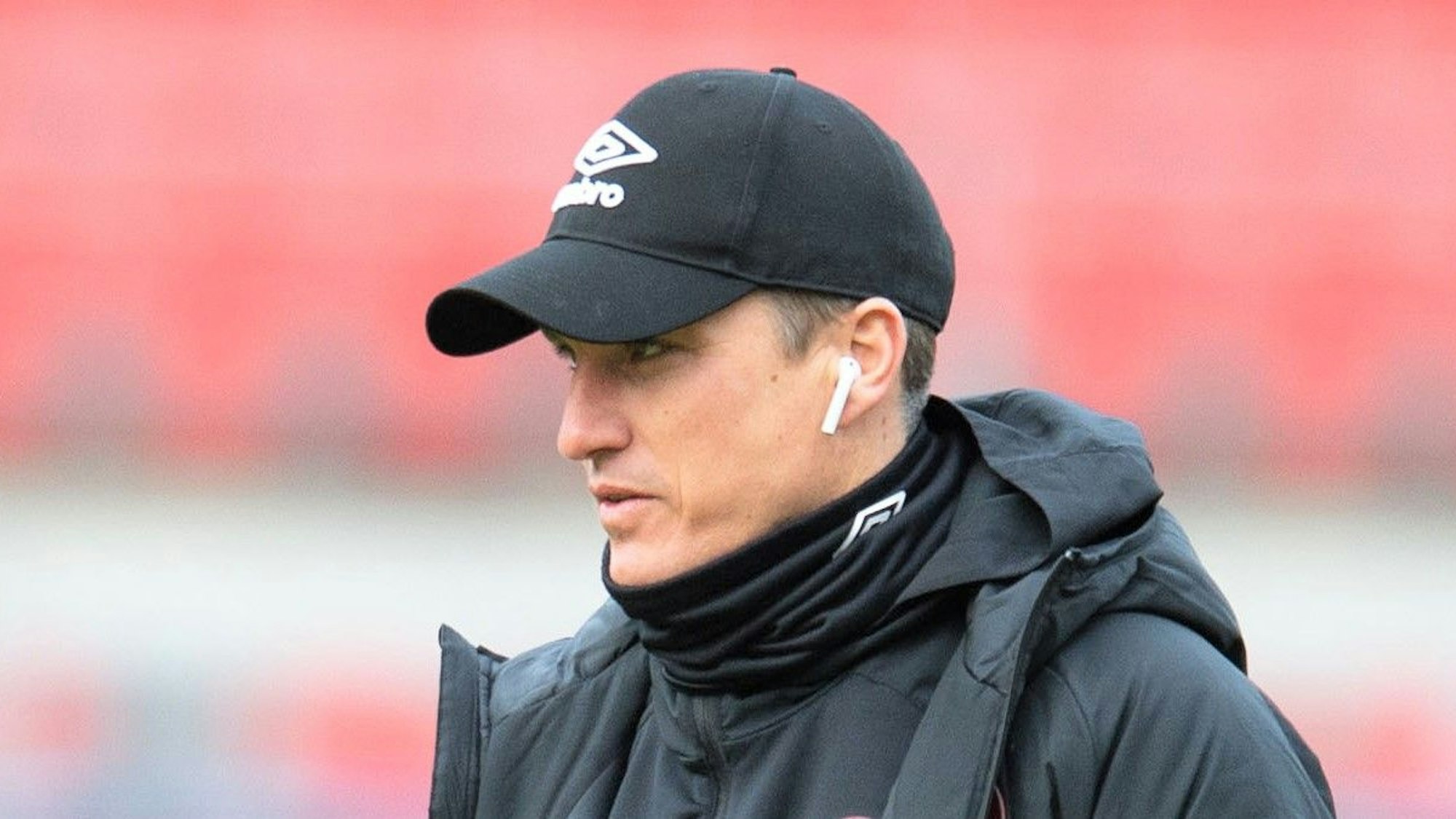 Tobias Schweinsteiger geht vor einem Spiel der 2. Bundesliga mit Kopfhörern in den Ohren über den Rasen