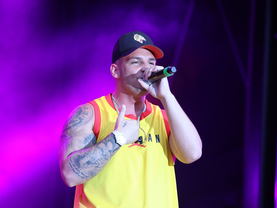 Der deutsche Sänger Pietro Lombardi tritt bei einem Sommer Open Air Konzert auf. Er trägt ein gelbes Tanktop und eine schwarze Kappe.