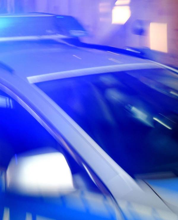 Ein Streifenwagen der Polizei steht mit eingeschaltetem Blaulicht auf der Strasse.