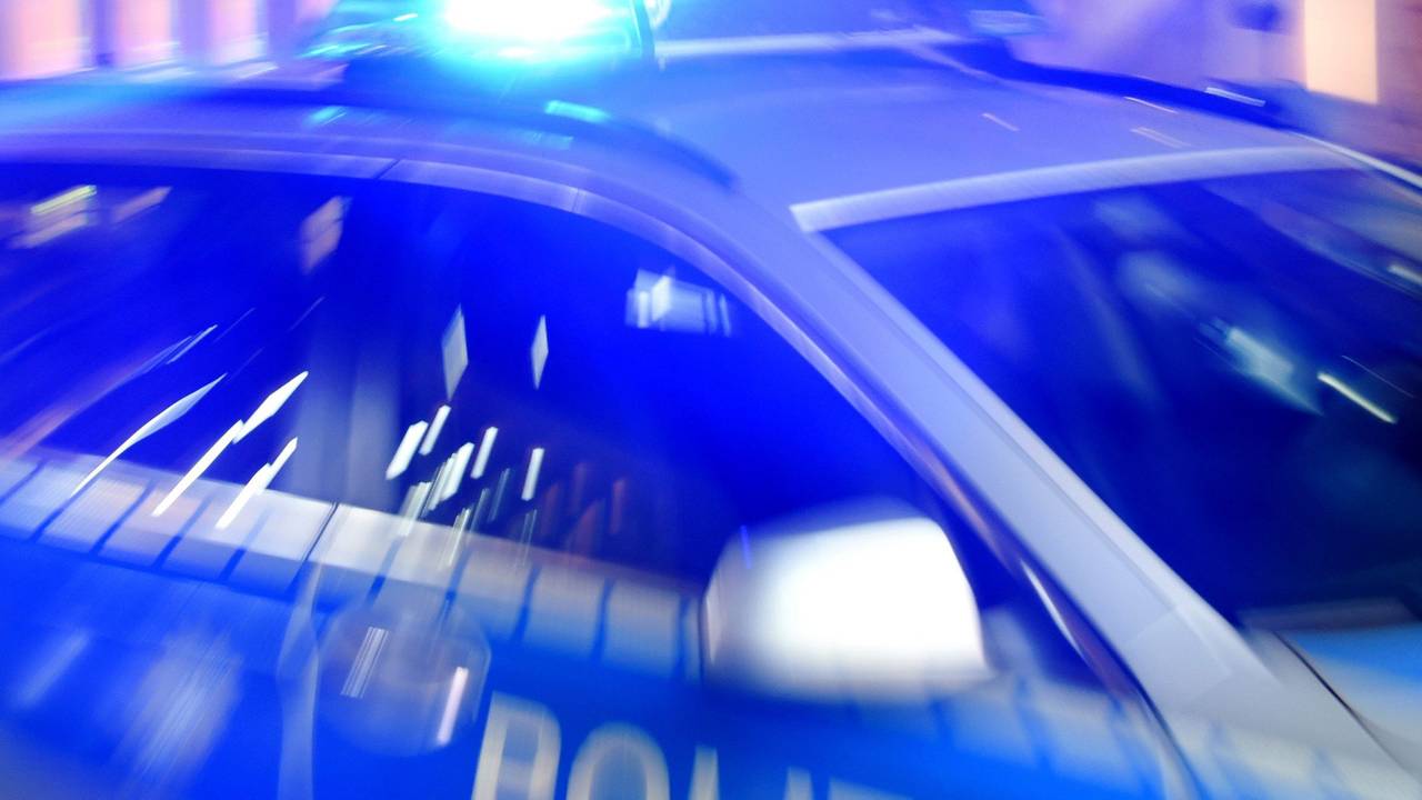 Ein Streifenwagen der Polizei steht mit eingeschaltetem Blaulicht auf der Strasse.