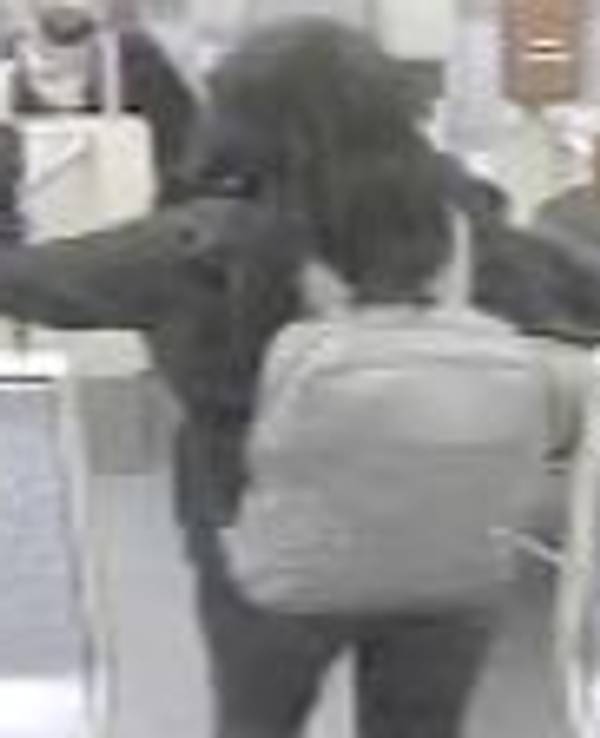 Das Fahndungsfoto zeigt eine Frau von hinten, die im März 2022 zwei Frauen fremdenfeindlich beleidigt und sie mit einem Rucksack attackiert haben soll.