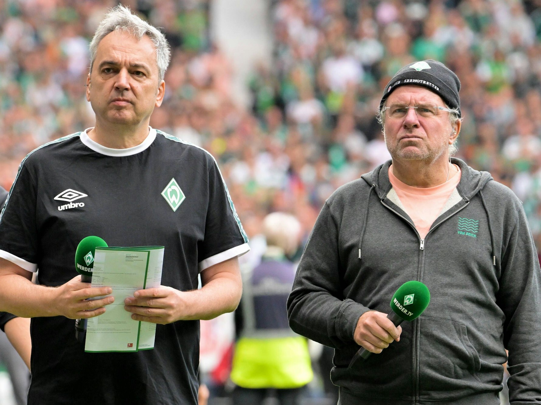 Arnd Zeigler und Christian Stoll stehen mit Mikrofonen vor dem Heimspiel im Weserstadion.