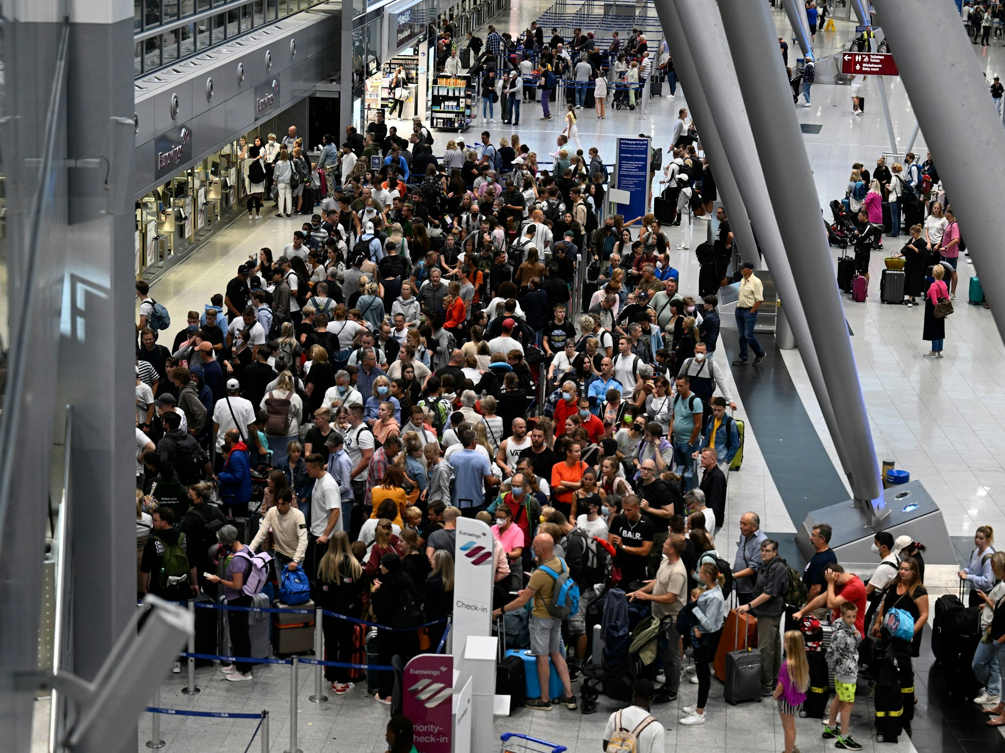 Reisende stehen am Flughafen Düsseldorf Schlange, aufgenommen am 27. Juli 2022.