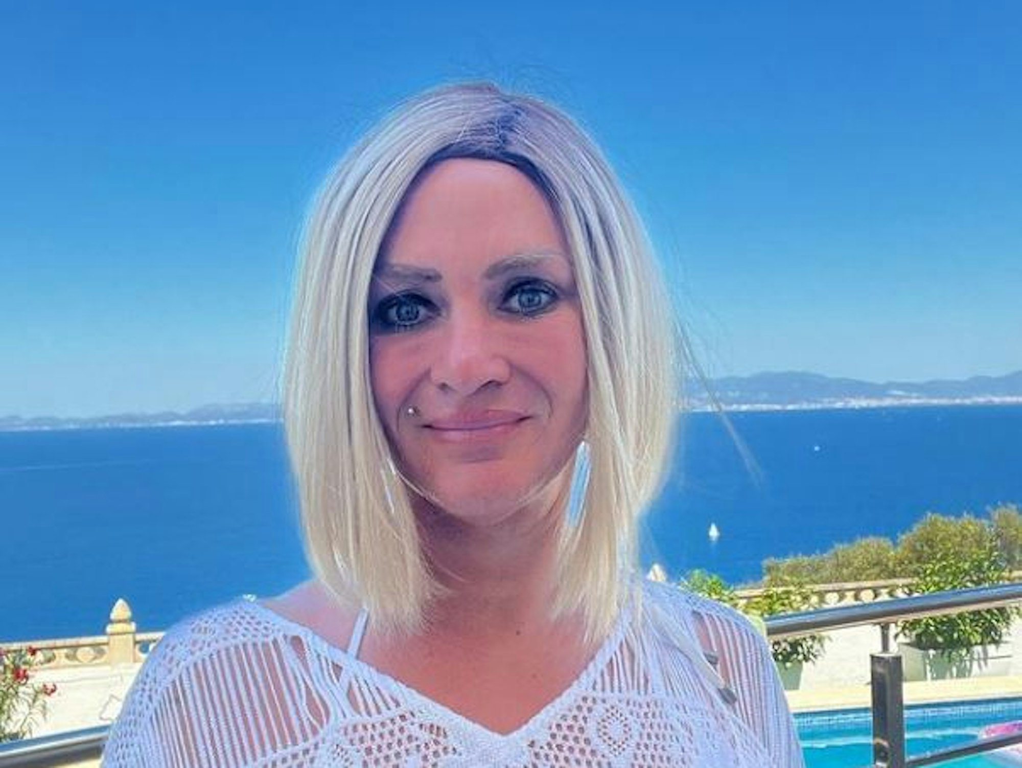 In einem Sommerkleid lacht Caro Robens fröhlich vor der malerischen Mittelmeer-Kulisse in die Kamera.