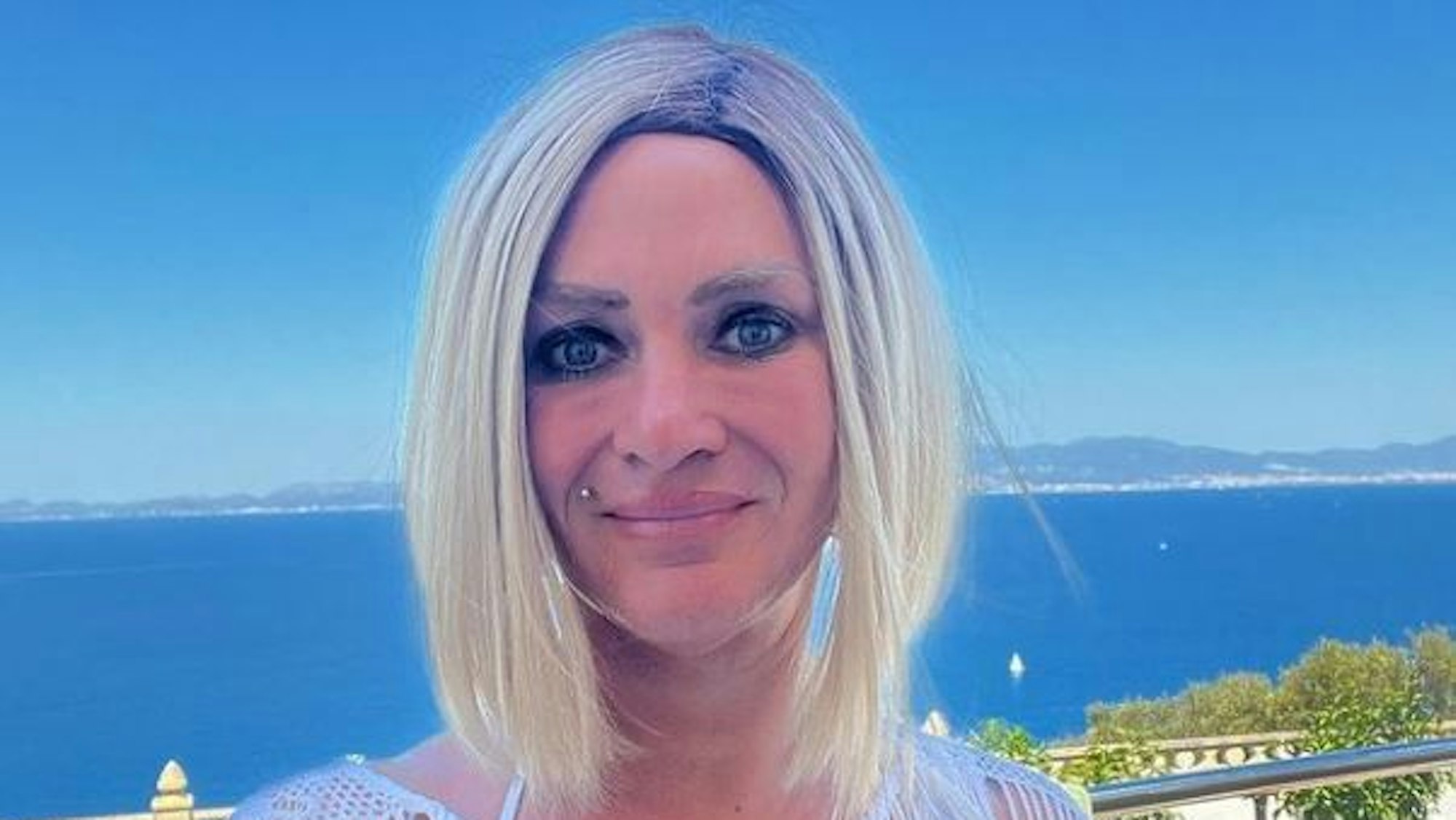 Caro Robens lächelt in die Kamera. Im Hintergrund ist das Mittelmeer vor der Küste Mallorcas zu sehen.