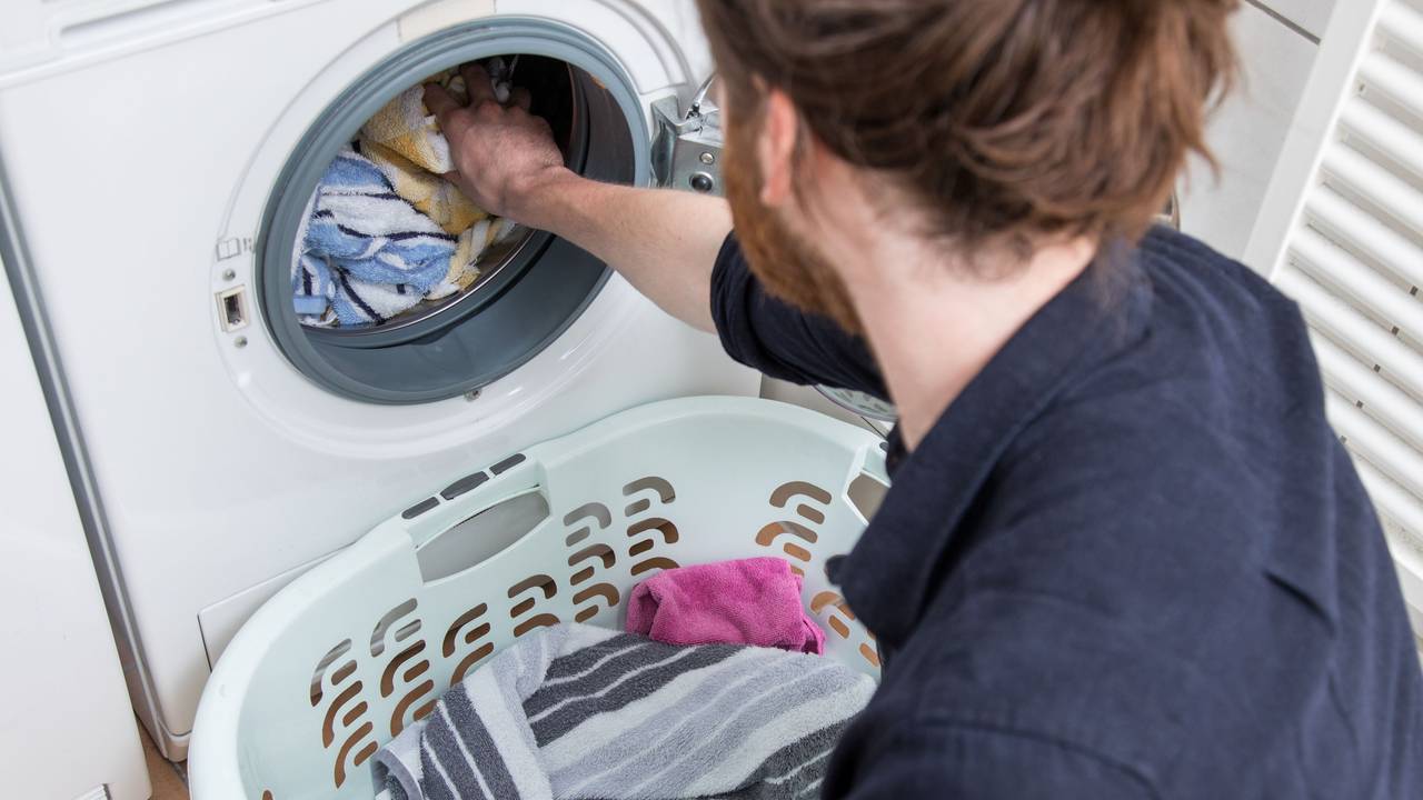 Auf dem Symbolbild lädt ein Mann gerade die Wäsche in eine Waschmaschine.