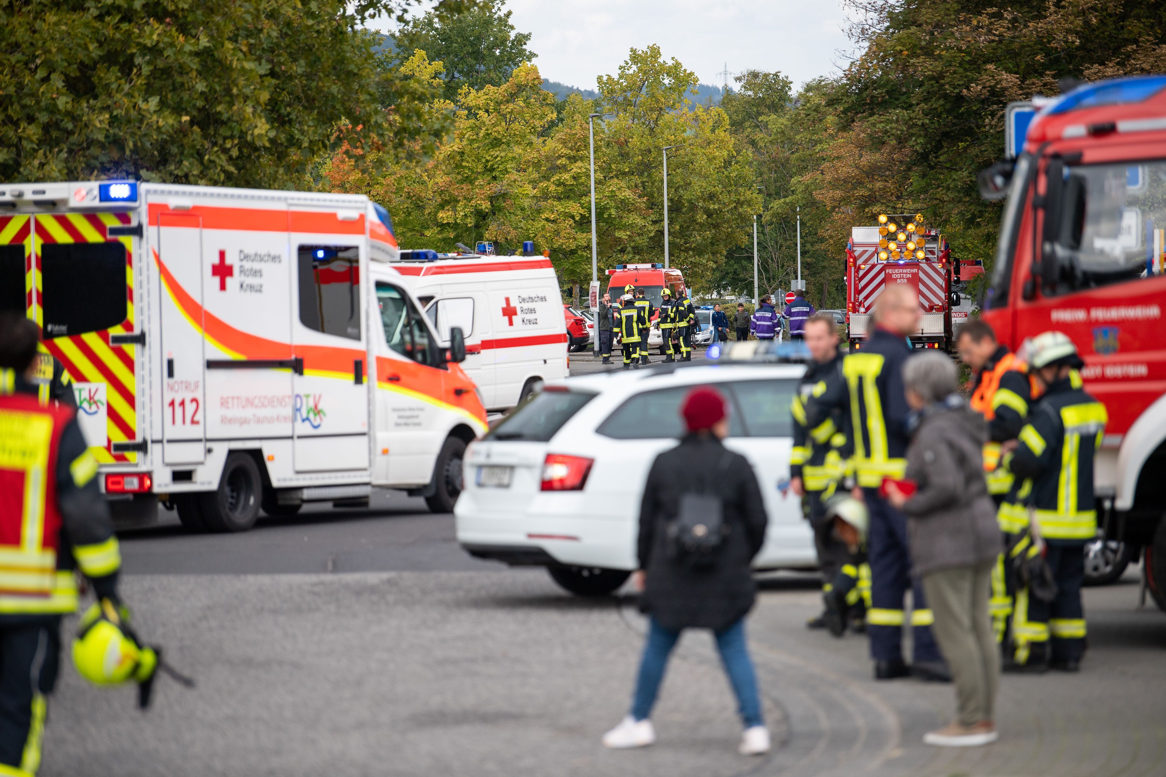 Einsatzkräfte der Feuerwehr und des Roten Kreuzes stehen nach einem Gasaustritt vor der Limesschule.