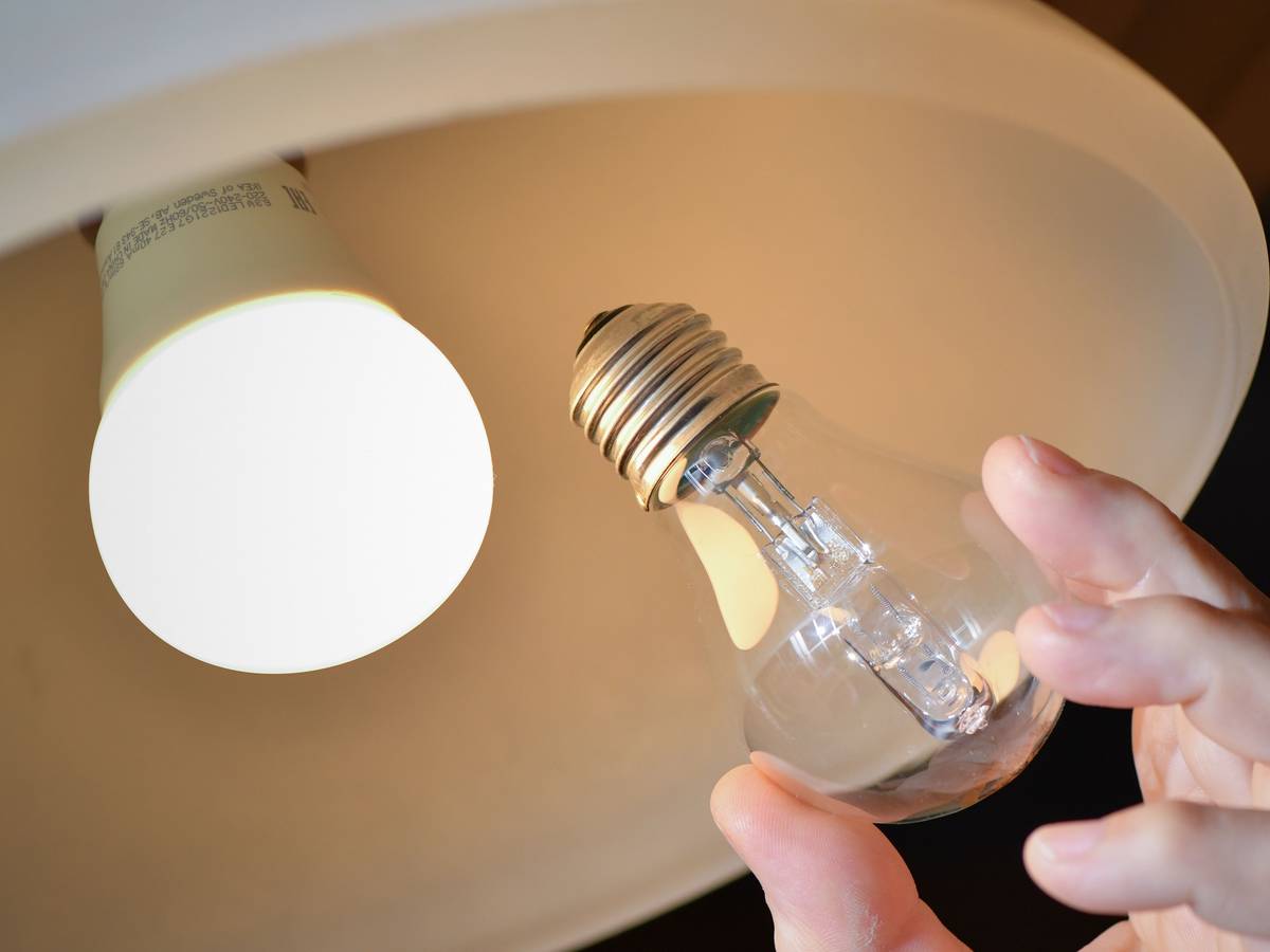 An einer Deckenleuchte wird eine Halogenlampe (r) gegen eine energiesparende LED-Lampe ausgewechselt.