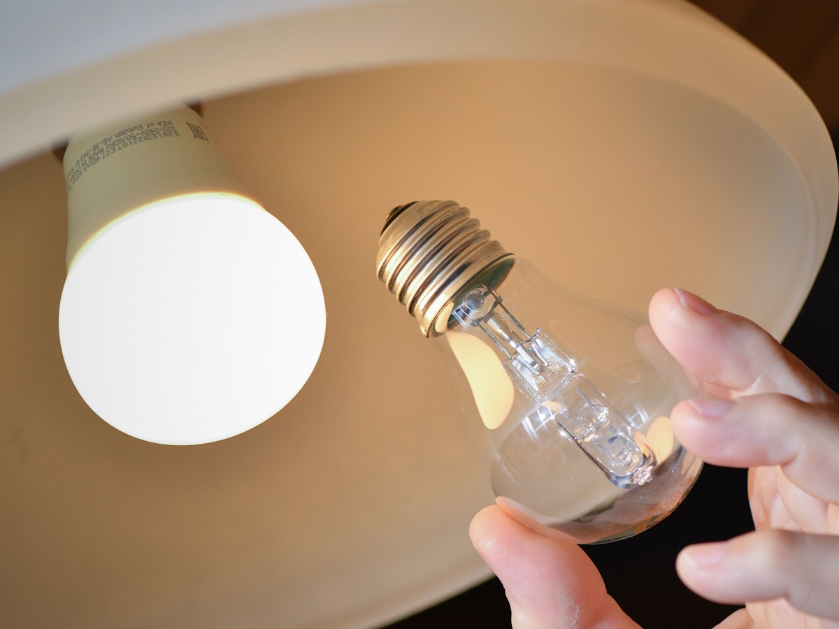 An einer Deckenleuchte wird eine Halogenlampe (r) gegen eine energiesparende LED-Lampe ausgewechselt.