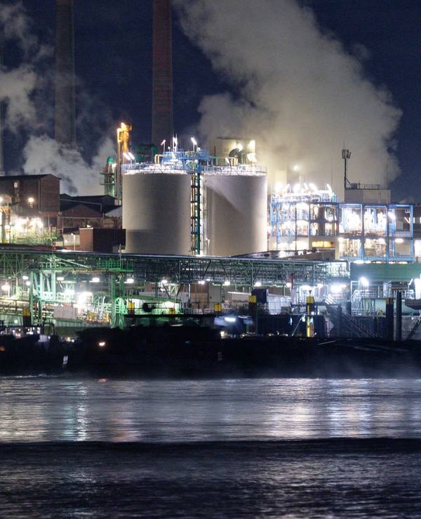 Die Lichter des Chemparks in Leverkusen spiegeln sich im Wasser des Rheins.