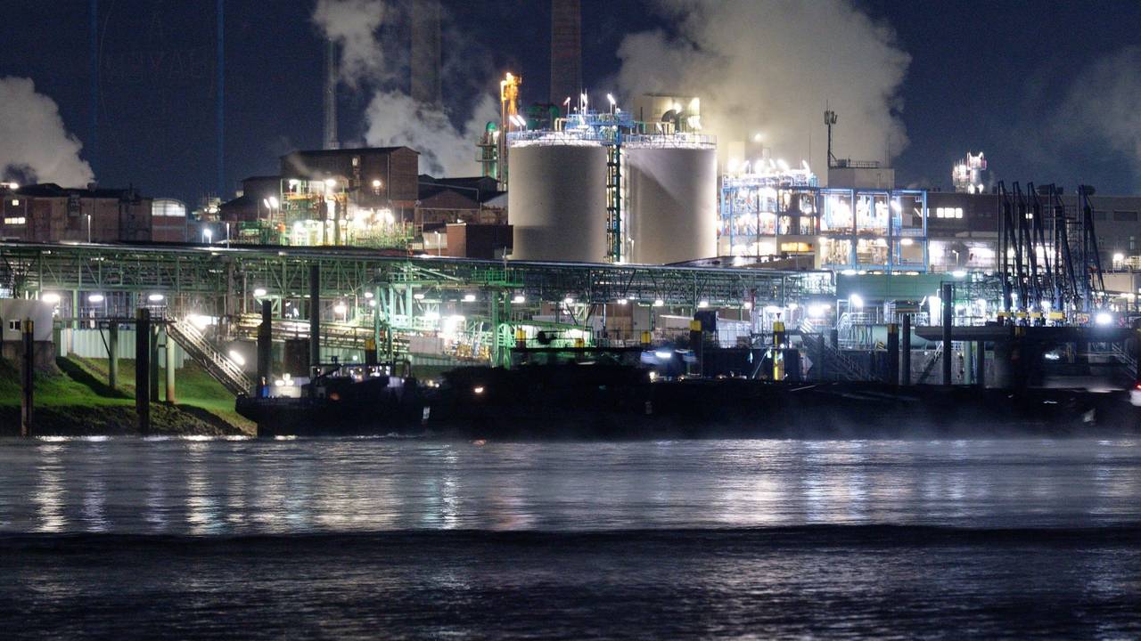 Die Lichter des Chemparks in Leverkusen spiegeln sich im Wasser des Rheins.