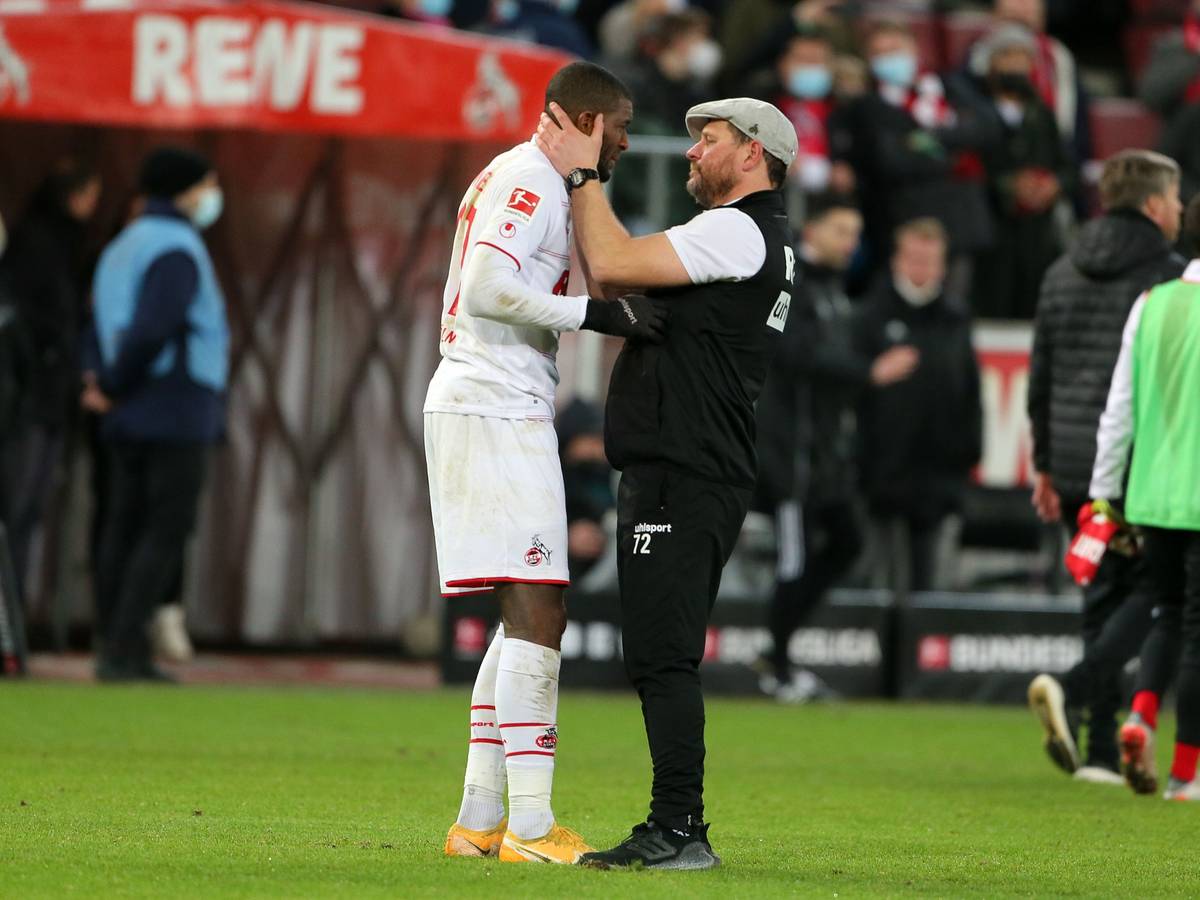 Anthony Modeste (l.) wird von 1. FC Köln-Trainer Steffen Baumgart (r.) am Rande eines Bundesligaspiels in den Arm genommen.