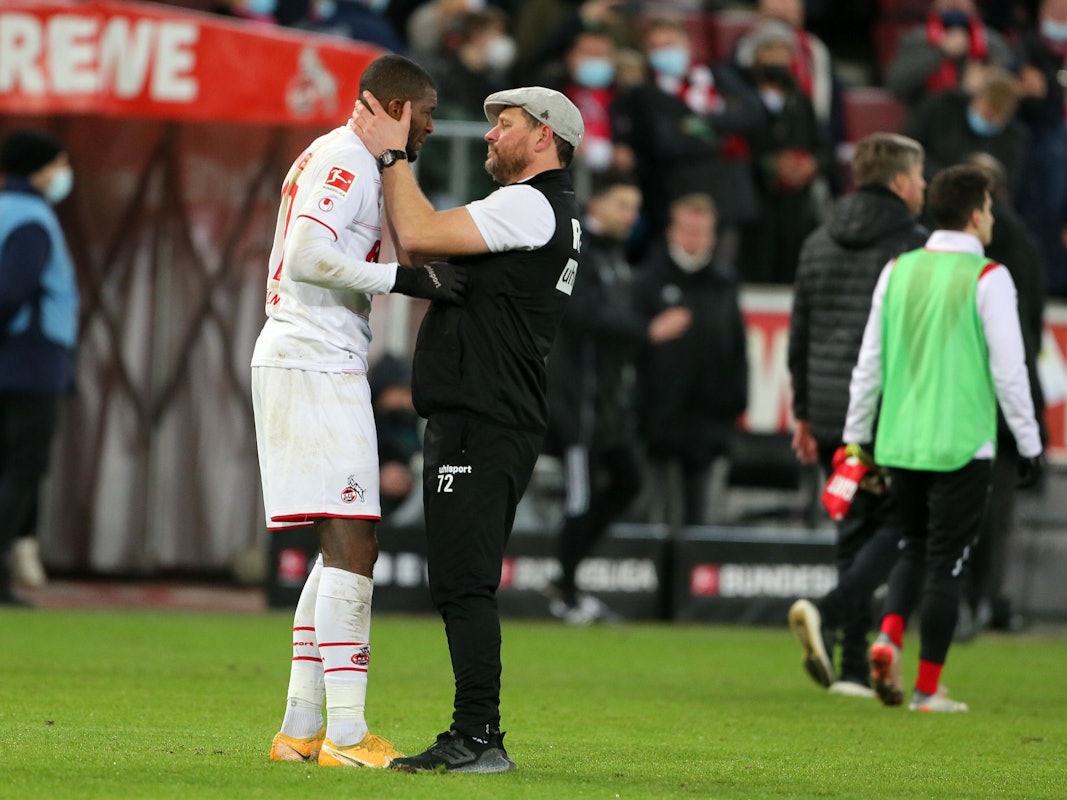Anthony Modeste (l.) wird von 1. FC Köln-Trainer Steffen Baumgart (r.) am Rande eines Bundesligaspiels in den Arm genommen.
