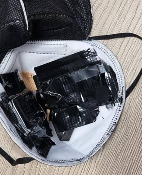 Eine eingenähte Kamera in einer FFP2-Maske liegt auf einem Tisch des TÜV Süd (undatierte Aufnahme). Sie war bei einer theoretischen Führerscheinprüfung entdeckt worden. Einen ähnlichen Betrugsfall gab es jetzt in Bergheim.
