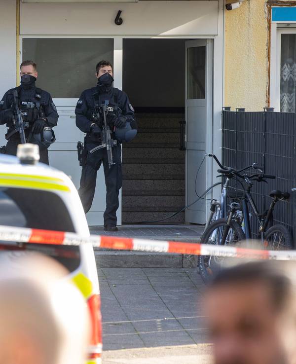 Polizisten stehen in Dormagen-Hackenbroich vor einem Kiosk.