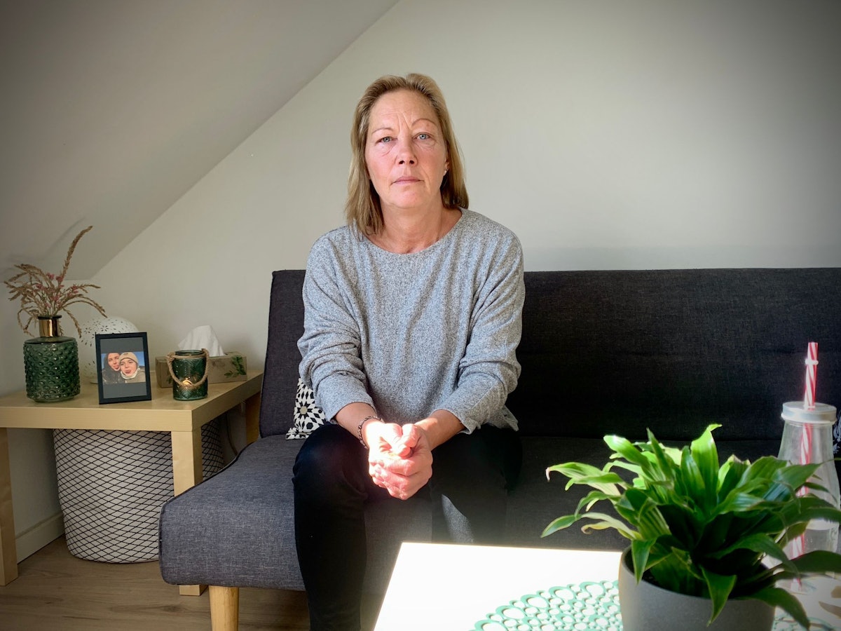 Deryas Mutter Rosi sitzt auf dem Sofa und schaut in die Kamera.